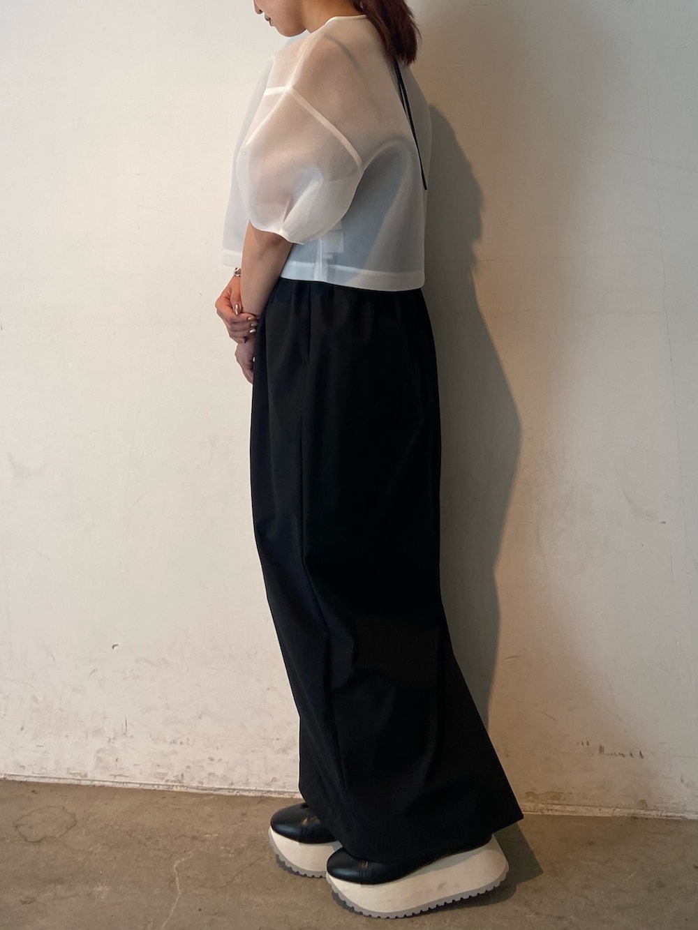 ホワイト系のシャツ/ブラウス、ブラック系のスカート、シルバー系のブレスレットを着用したレディースの春コーディネートの3枚目の写真