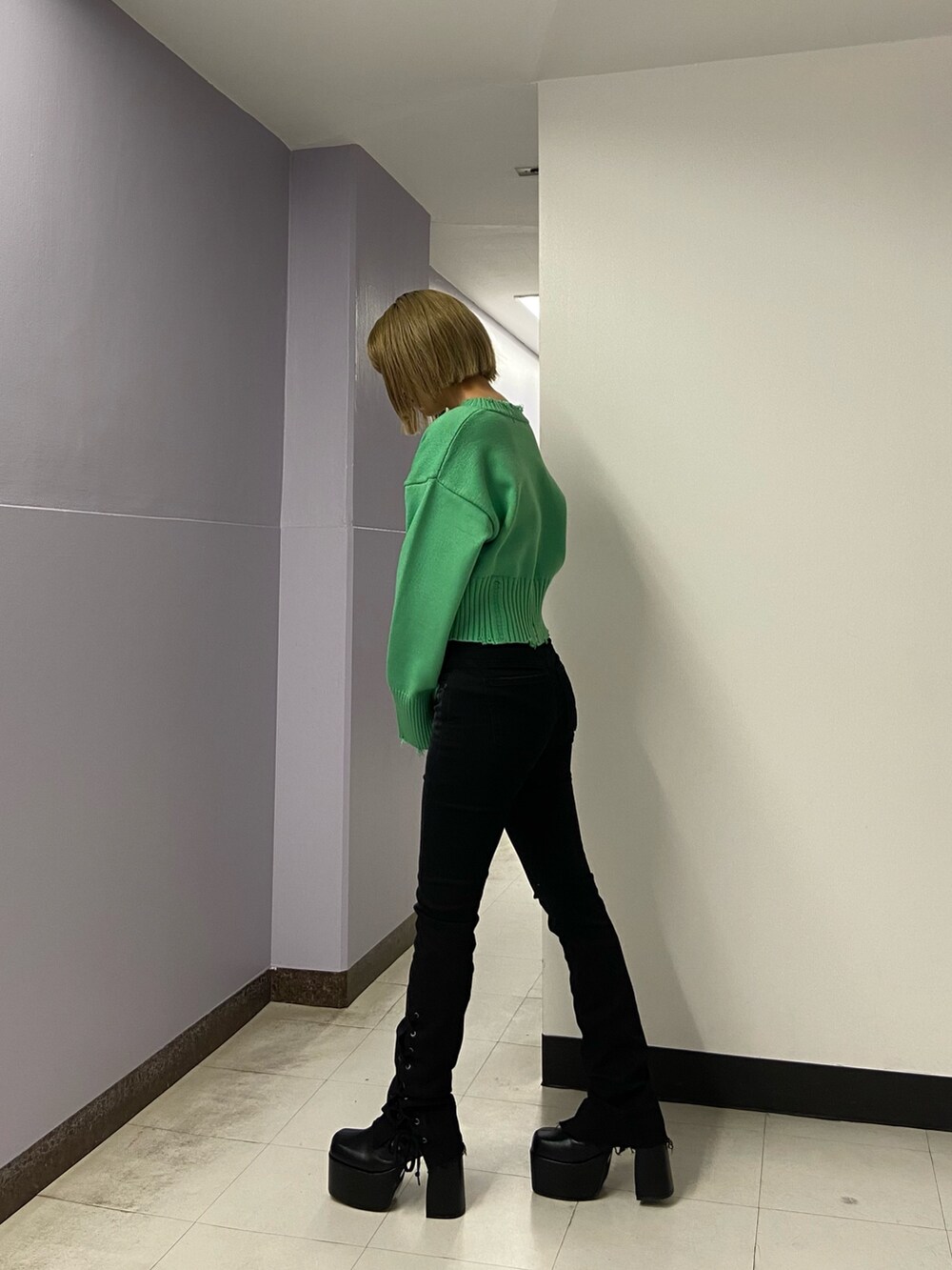 ブラック系のパンツ、グリーン系のニット/セーター、ブラック系のブーツを着用したレディースの冬コーディネートの3枚目の写真