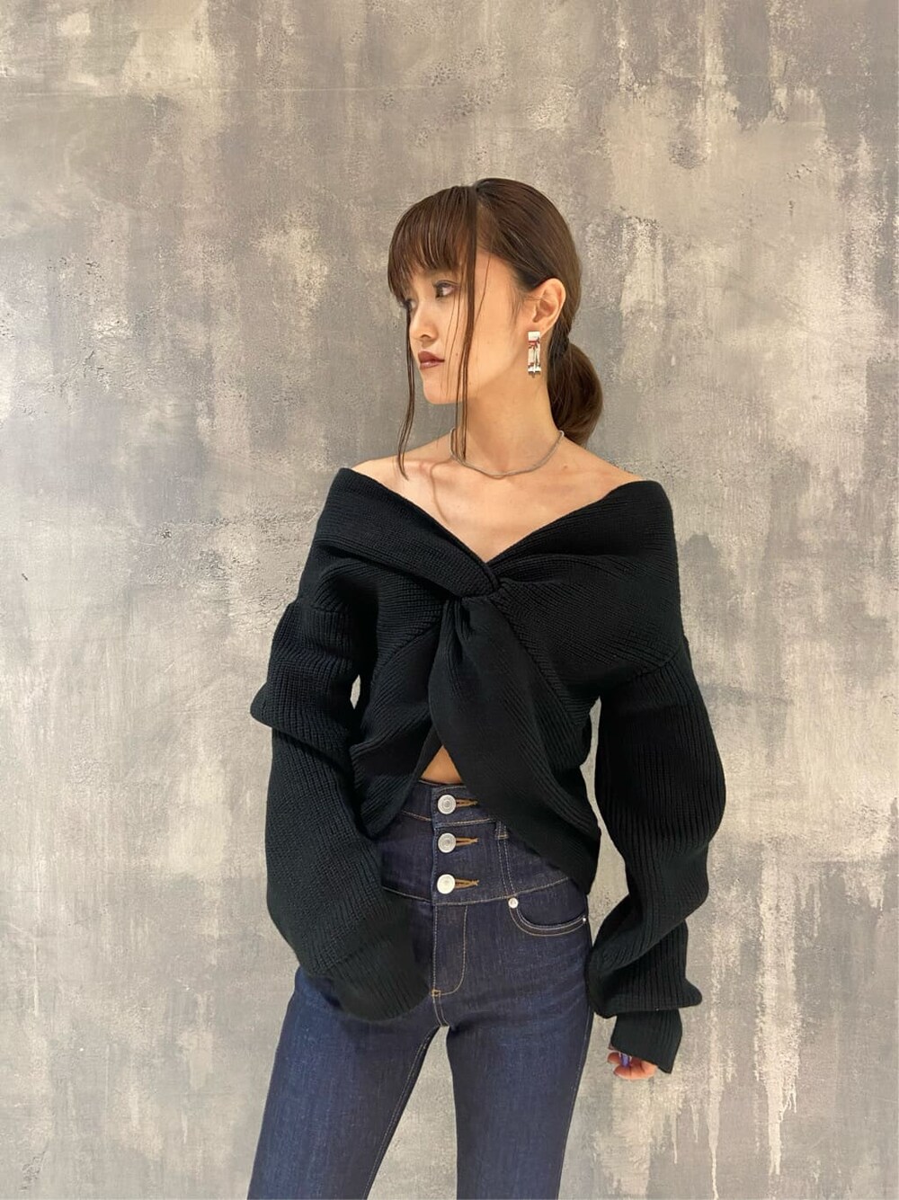 ブラック系のローファー、ブルー系のデニムパンツ、ブラック系のニット/セーターを着用したレディースの秋コーディネートの2枚目の写真