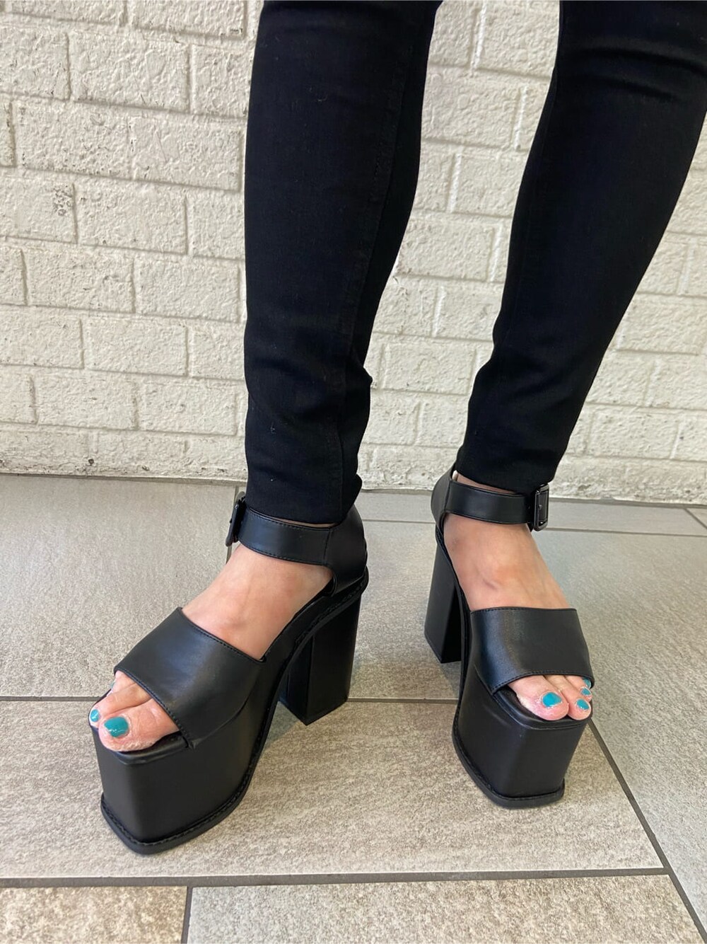 ブラック系のデニムパンツ、ブラック系のサンダル、ホワイト系のTシャツ/カットソーを着用したレディースの夏コーディネートの7枚目の写真