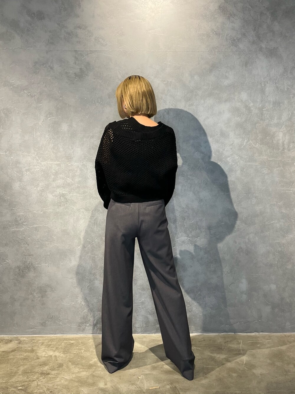 ブラック系のパンプス、グレー系のその他パンツ、ブラック系のニット/セーターを着用したレディースの春コーディネートの4枚目の写真