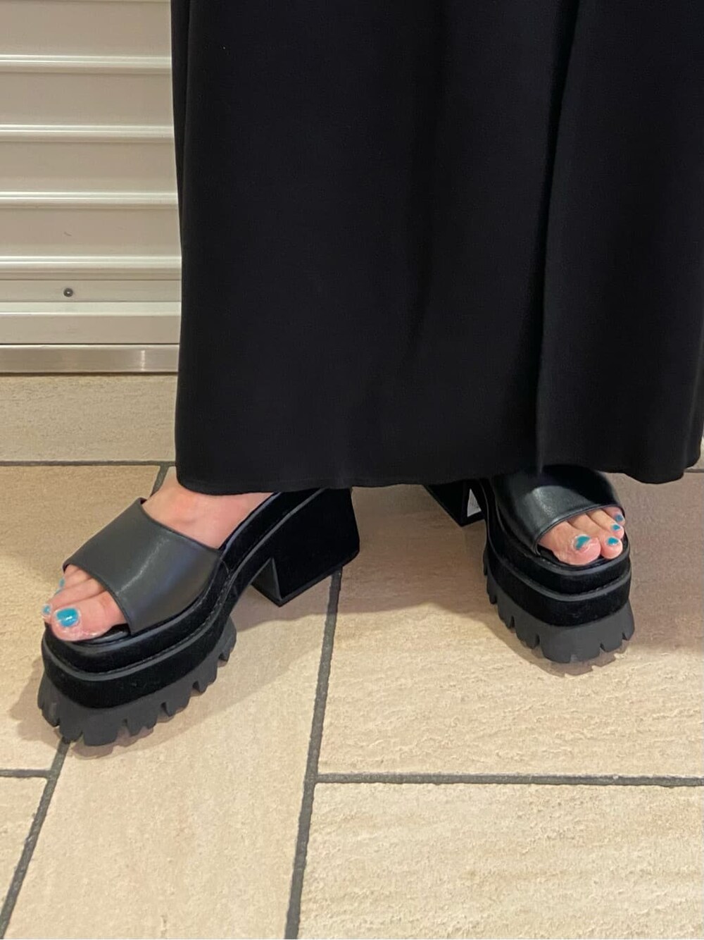 ブラック系のスカート、ブラック系のサンダル、グレー系のTシャツ/カットソーを着用したレディースの夏コーディネートの8枚目の写真