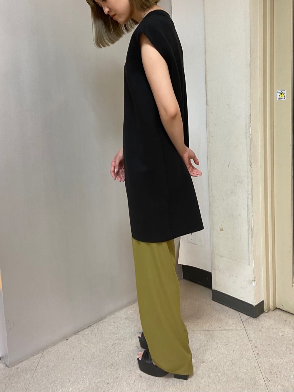 ブラック系のサンダル、ブラック系のワンピース、イエロー系のその他パンツを着用したレディースの夏コーディネートの2枚目の写真