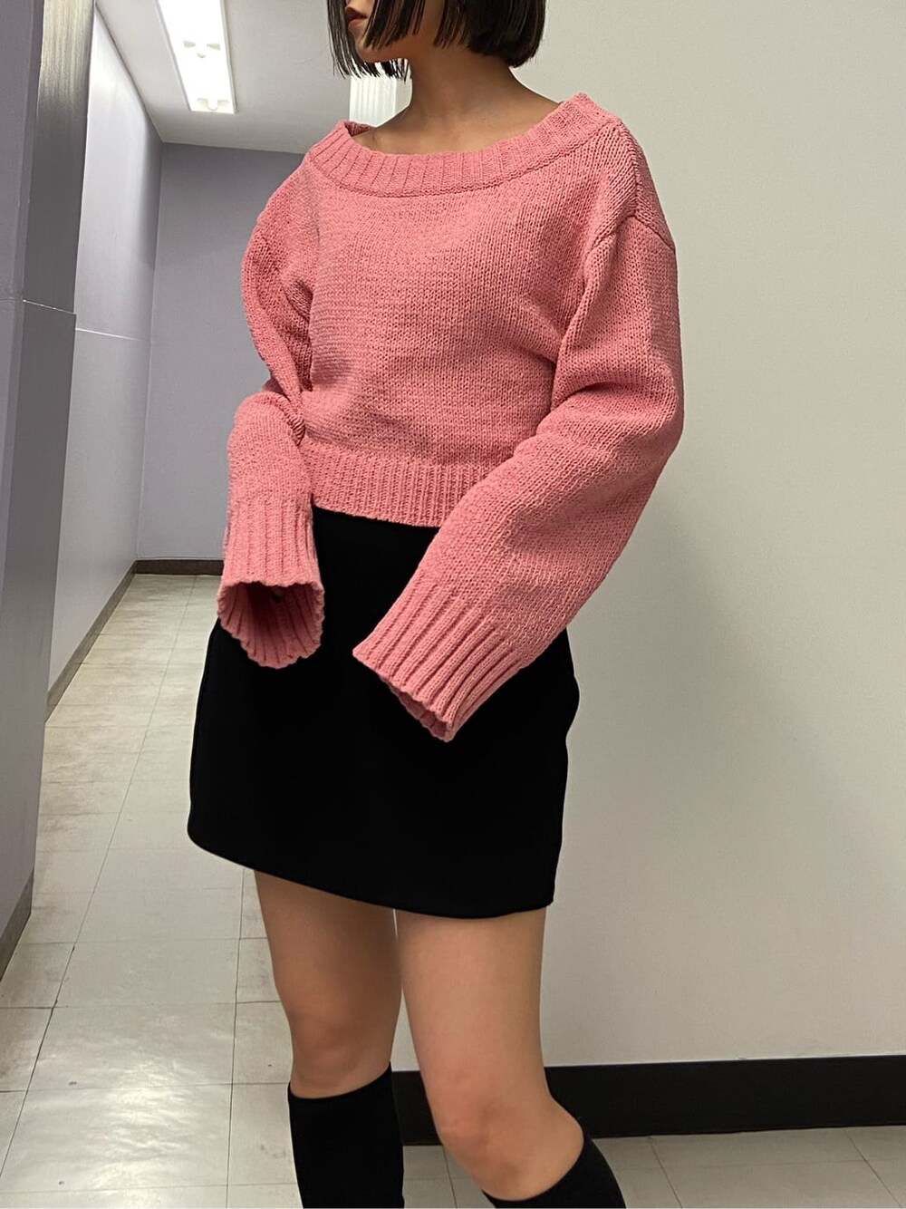 ブラック系のブーツ、ブラック系のスカート、ピンク系のニット/セーターを着用したレディースの秋コーディネートの5枚目の写真