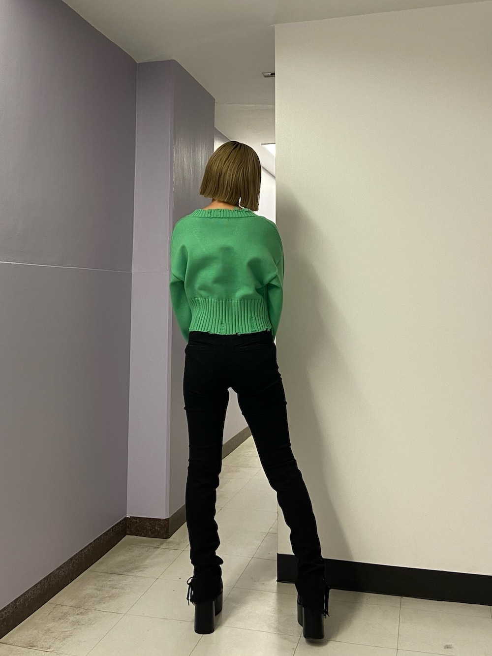 ブラック系のパンツ、グリーン系のニット/セーター、ブラック系のブーツを着用したレディースの冬コーディネートの4枚目の写真