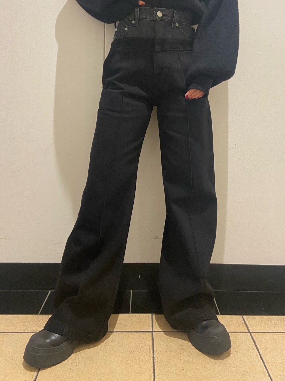 ブラック系のブーツ、ブルー系のニット/セーター、ブラック系のデニムパンツを着用したレディースの冬コーディネートの6枚目の写真