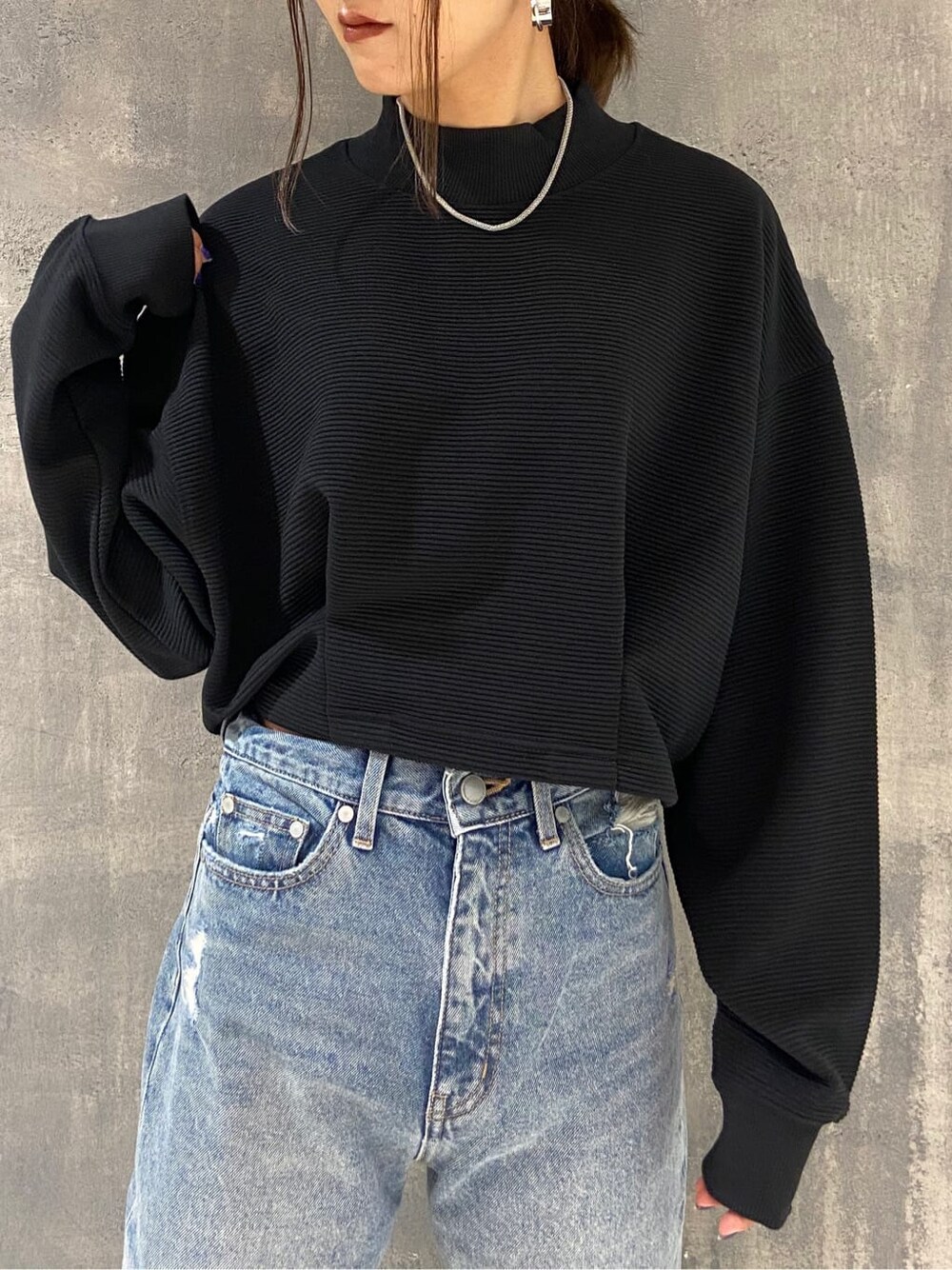 ブラック系のブーツ、ブラック系のTシャツ/カットソー、ブルー系のデニムパンツを着用したレディースの秋コーディネートの3枚目の写真