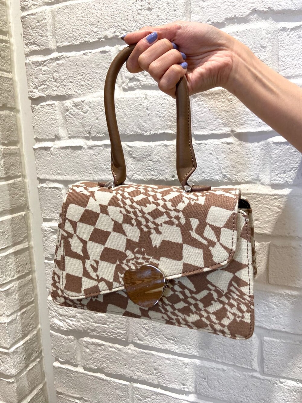 その他のハンドバッグ、ブラック系のワンピース、ブラック系のサンダルを着用したレディースの春コーディネートの7枚目の写真