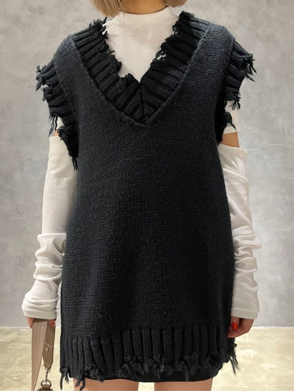 ホワイト系のTシャツ/カットソー、ブラウン系のハンドバッグ、ブラック系のスカートを着用したレディースの秋コーディネートの4枚目の写真