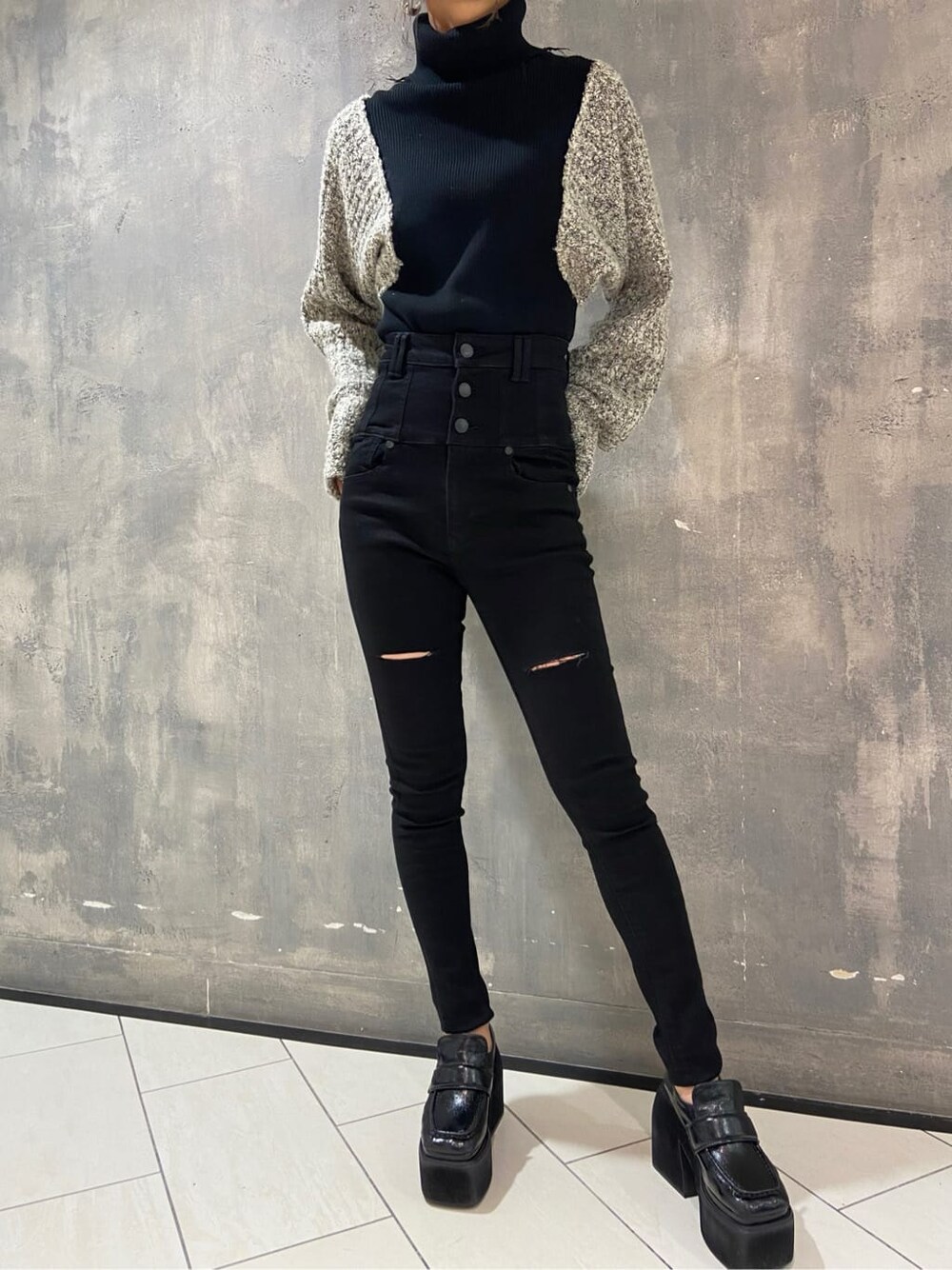 ブラック系のローファー、ブラック系のニット/セーター、ブラック系のデニムパンツを着用したレディースの秋コーディネートの6枚目の写真