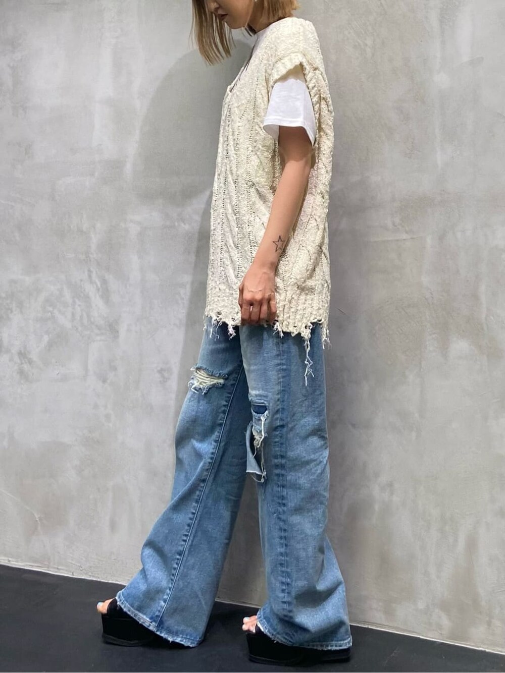 ブルー系のデニムパンツ、ホワイト系のベスト、ホワイト系のTシャツ/カットソーを着用したレディースの夏コーディネートの4枚目の写真