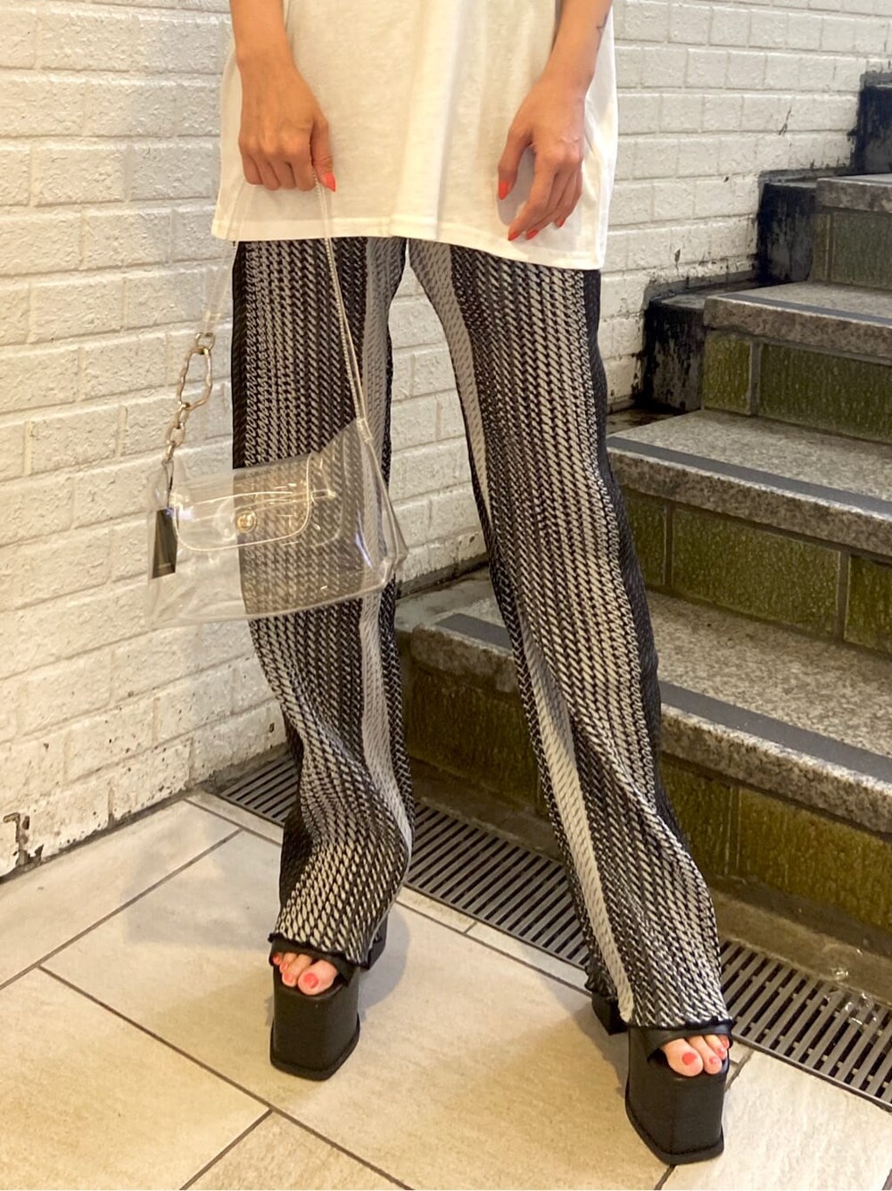 ブラック系のサンダル、その他のその他パンツ、ホワイト系のTシャツ/カットソーを着用したレディースの春コーディネートの6枚目の写真