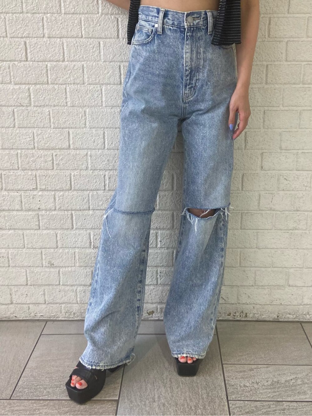 ブラック系のサンダル、ブルー系のデニムパンツ、その他のアンサンブルを着用したレディースの夏コーディネートの7枚目の写真