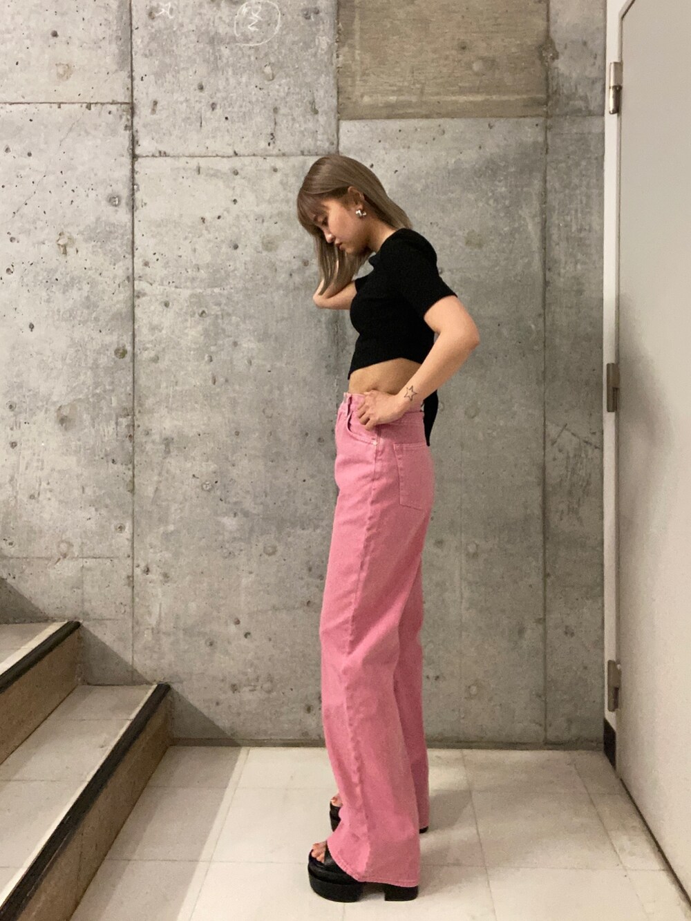 ブラック系のTシャツ/カットソー、ピンク系のデニムパンツ、ブラック系のサンダルを着用したレディースの春コーディネートの2枚目の写真