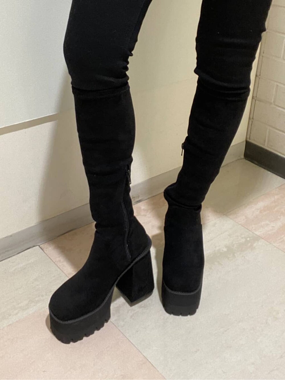 ブラック系のデニムパンツ、ブラック系のブーツ、イエロー系のニット/セーターを着用したレディースの冬コーディネートの6枚目の写真