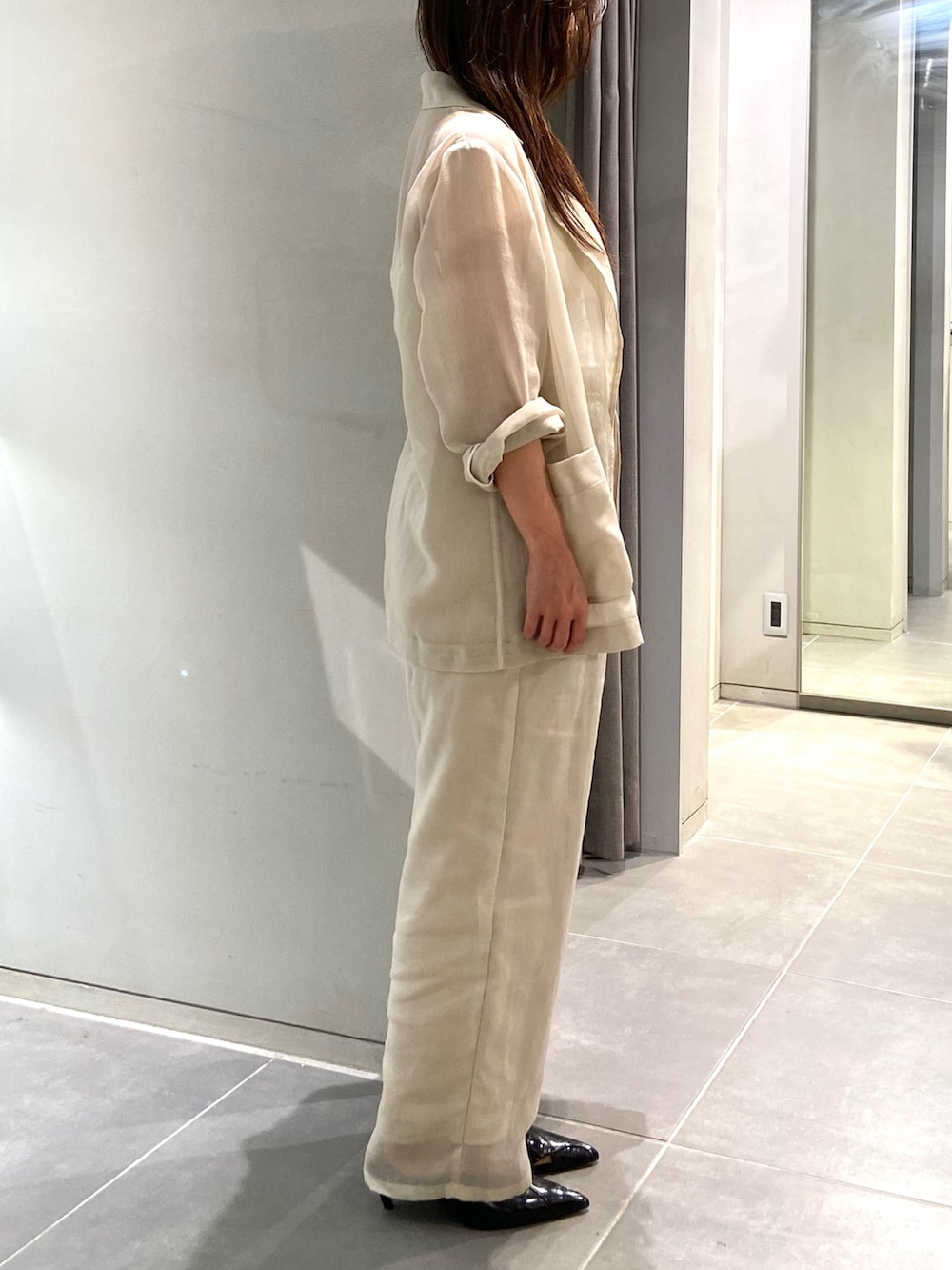 ホワイト系のテーラードジャケット、ホワイト系のその他パンツ、ブラック系のパンプスを着用したレディースの春コーディネートの3枚目の写真