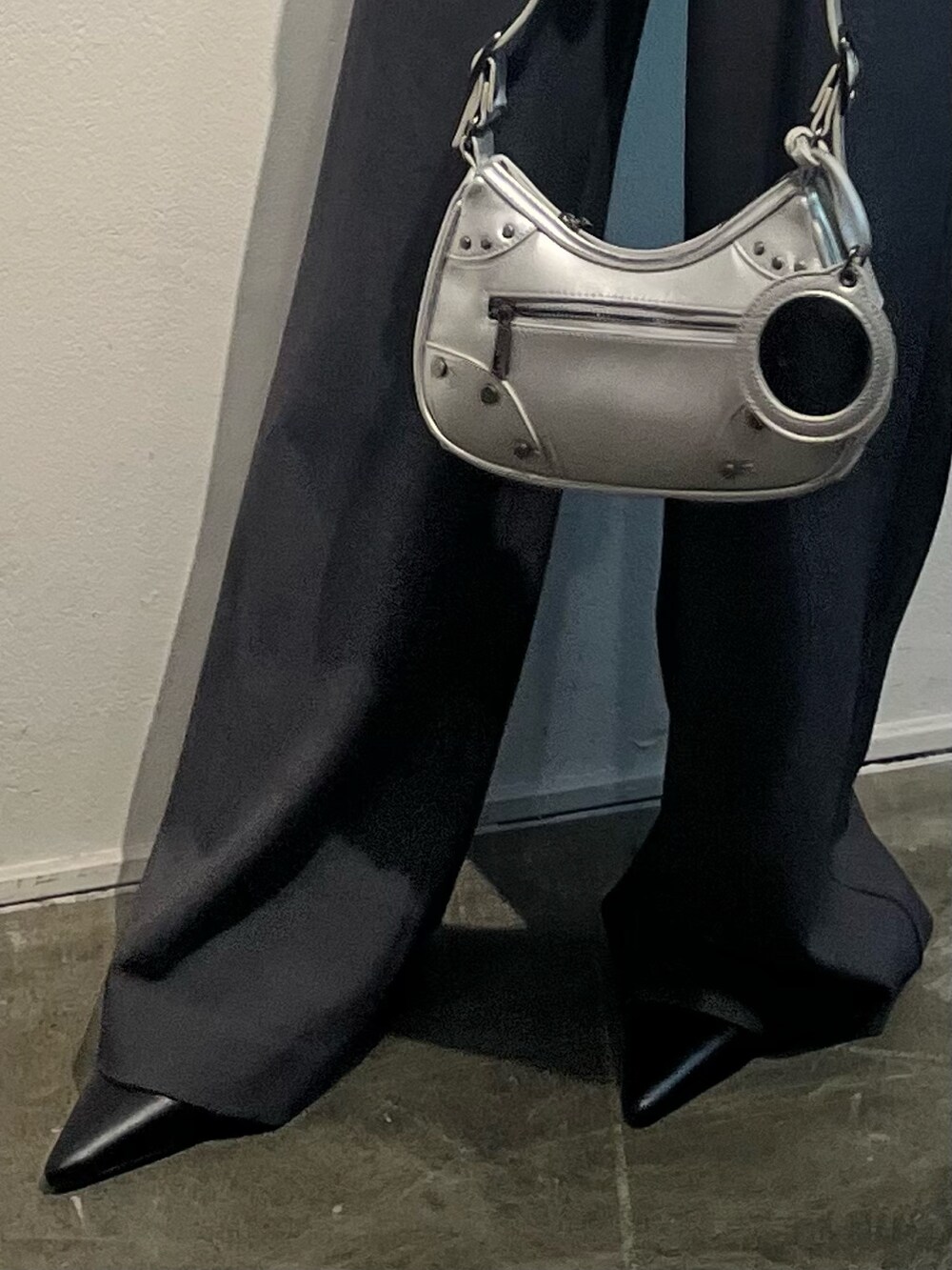 ブラック系のシャツ/ブラウス、グレー系のその他パンツ、シルバー系のハンドバッグを着用したレディースの冬コーディネートの6枚目の写真