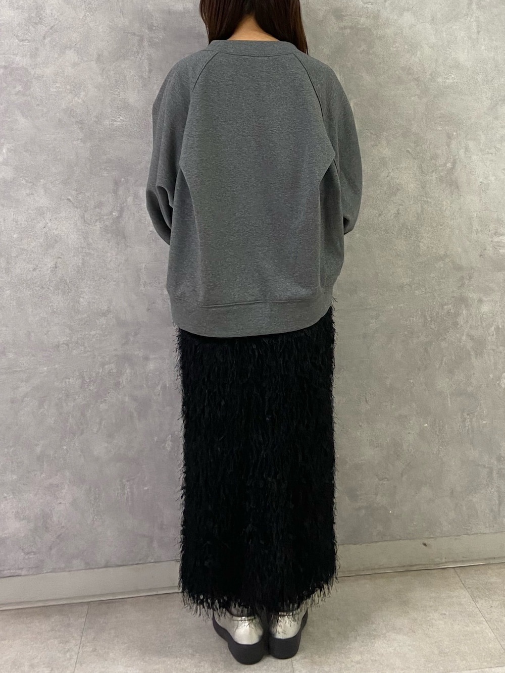 グレー系のTシャツ/カットソー、ブラック系のスカート、シルバー系のローファーを着用したレディースの冬コーディネートの4枚目の写真