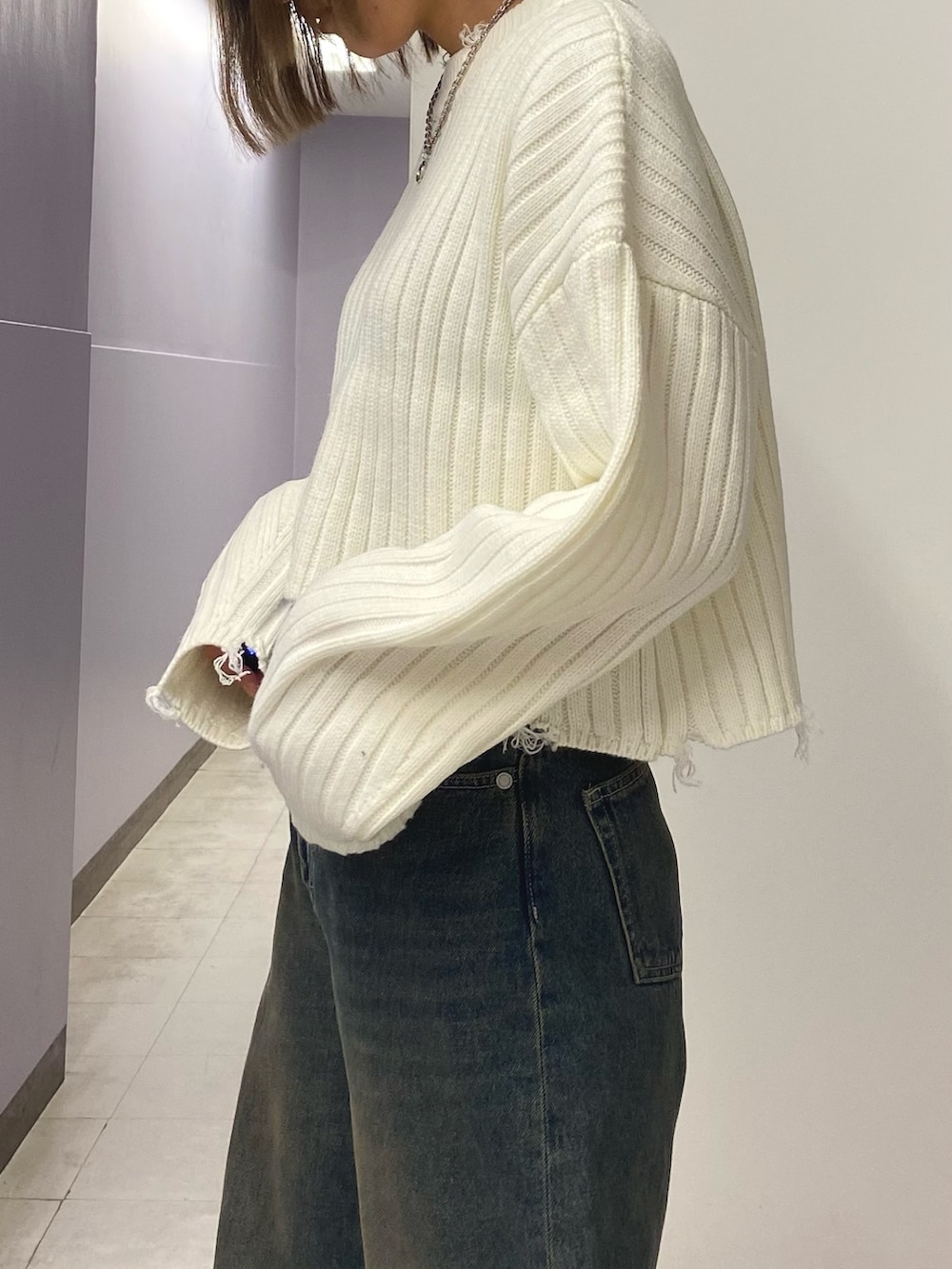 ホワイト系のニット/セーター、ブルー系のデニムパンツ、ブラック系のブーツを着用したレディースの秋コーディネートの4枚目の写真