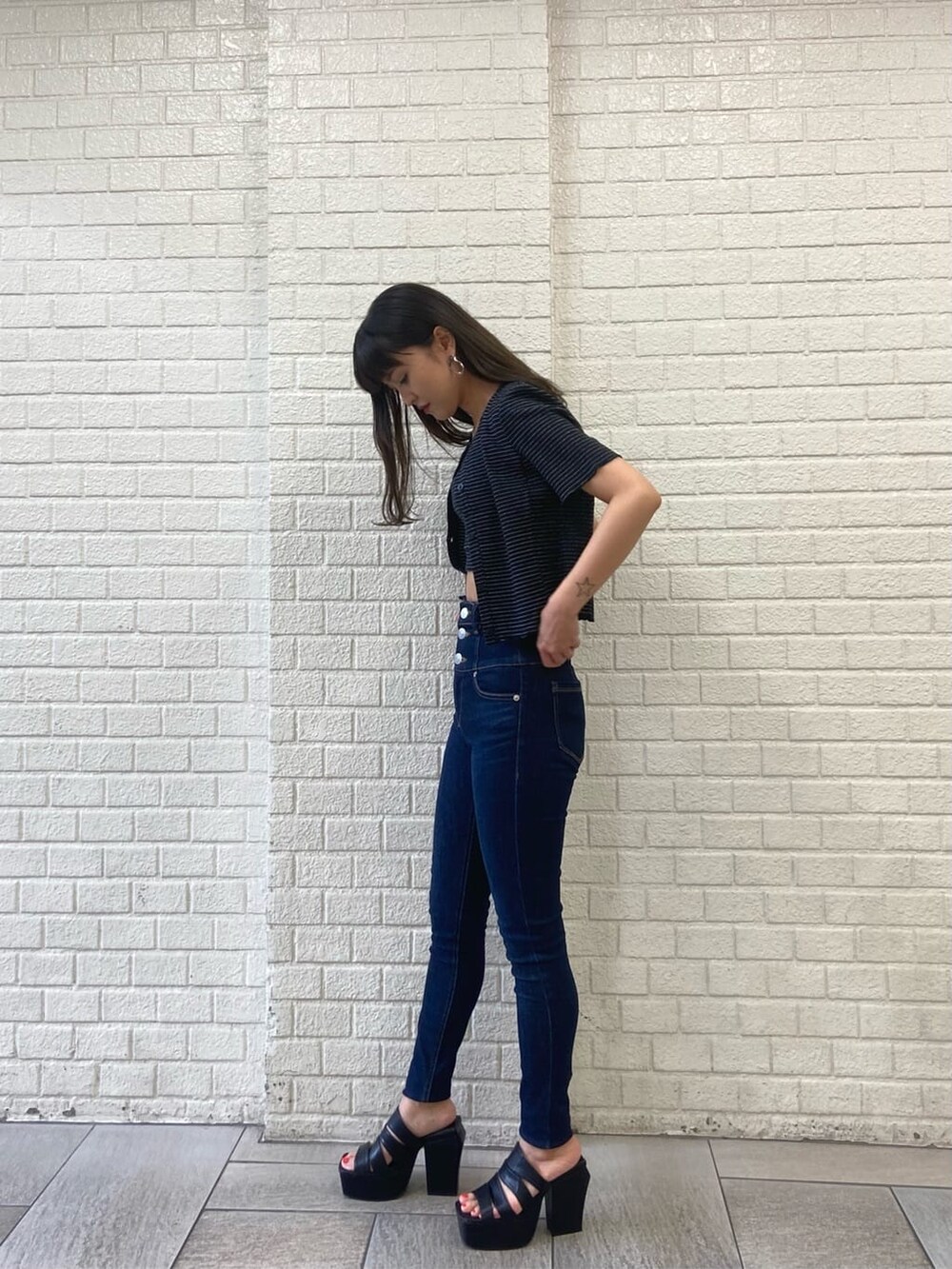 ブルー系のデニムパンツ、ブラック系のサンダル、その他のアンサンブルを着用したレディースの夏コーディネートの2枚目の写真