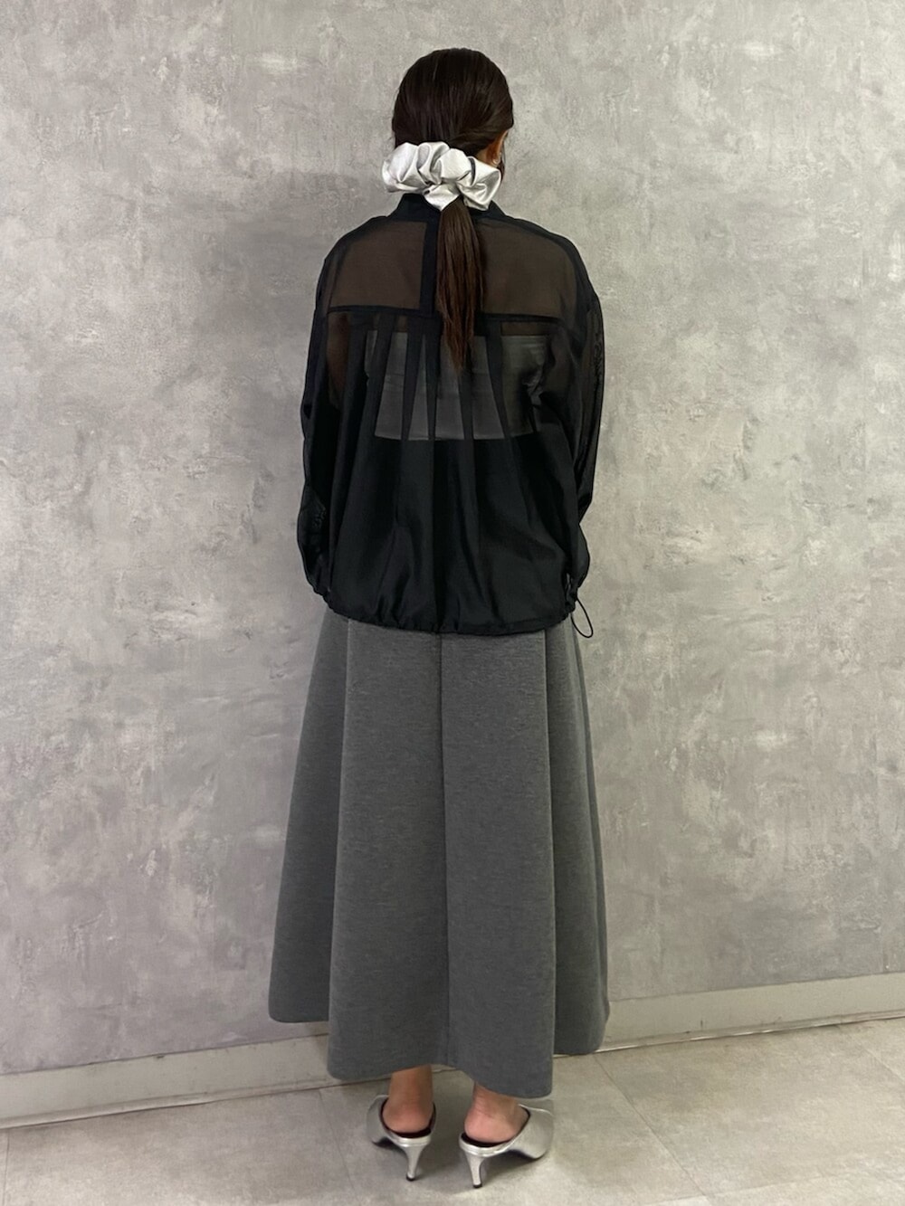 シルバー系のパンプス、ホワイト系のキャミソール、ブラック系のブルゾンを着用したレディースの春コーディネートの4枚目の写真