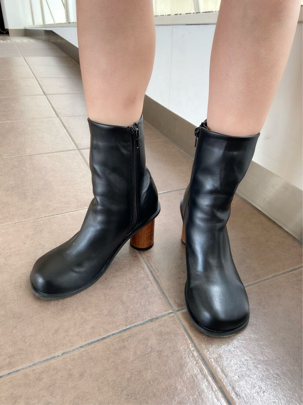 ホワイト系のテーラードジャケット、ブラック系のブーツ、ホワイト系のスカートを着用したレディースの春コーディネートの7枚目の写真