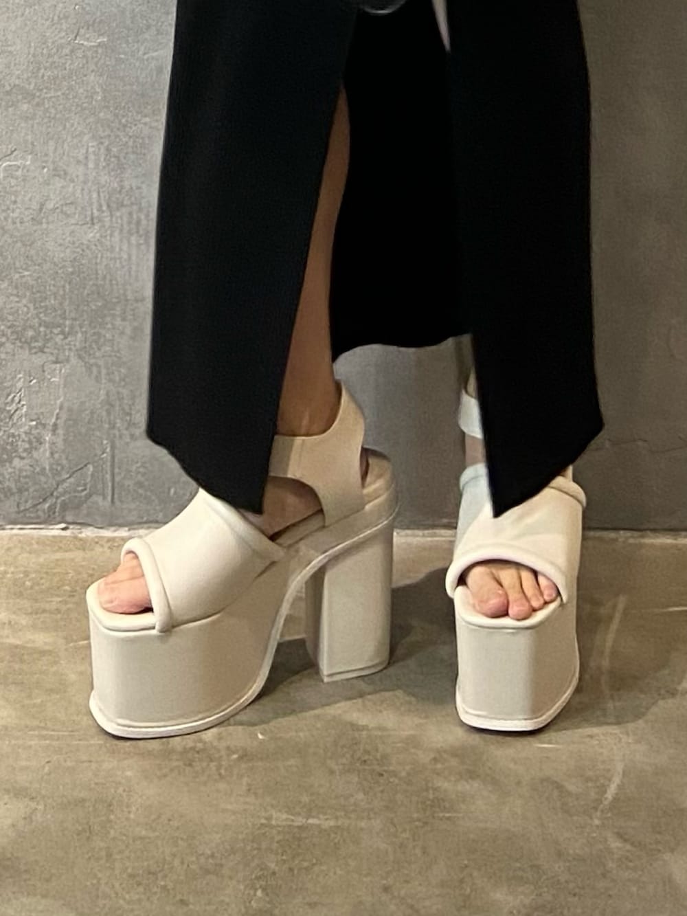 ブラック系のワンピース、ブラック系のショルダーバッグ、ホワイト系のサンダルを着用したレディースの春コーディネートの6枚目の写真