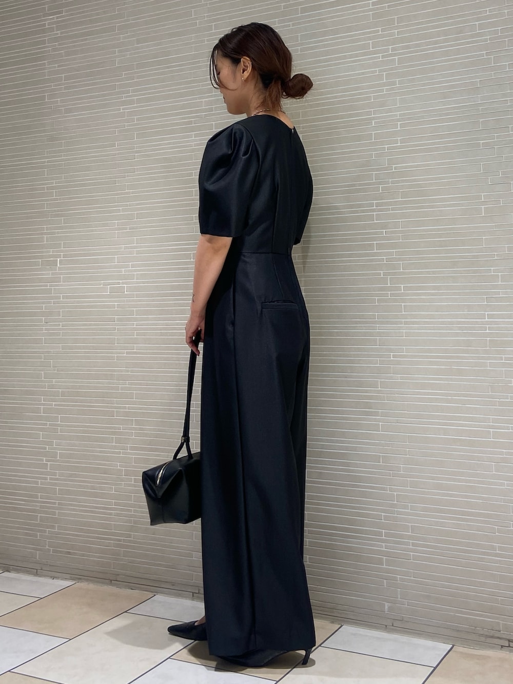 ブラック系のつなぎ/オールインワン、ブラック系のサンダル、ブラック系のボストンバッグを着用したレディースの夏コーディネートの2枚目の写真