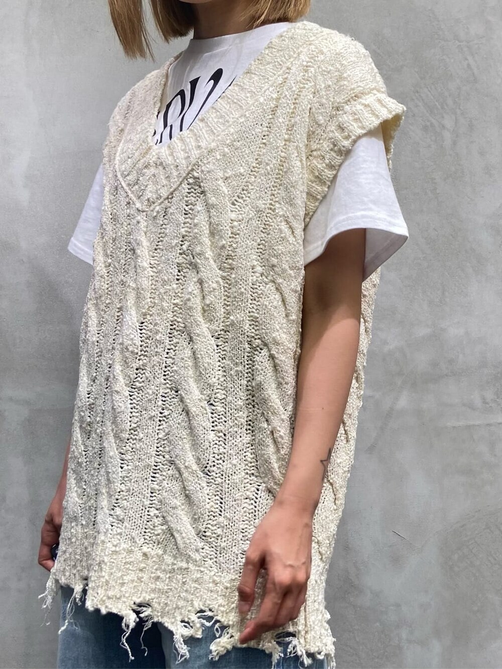 ブルー系のデニムパンツ、ホワイト系のベスト、ホワイト系のTシャツ/カットソーを着用したレディースの夏コーディネートの6枚目の写真