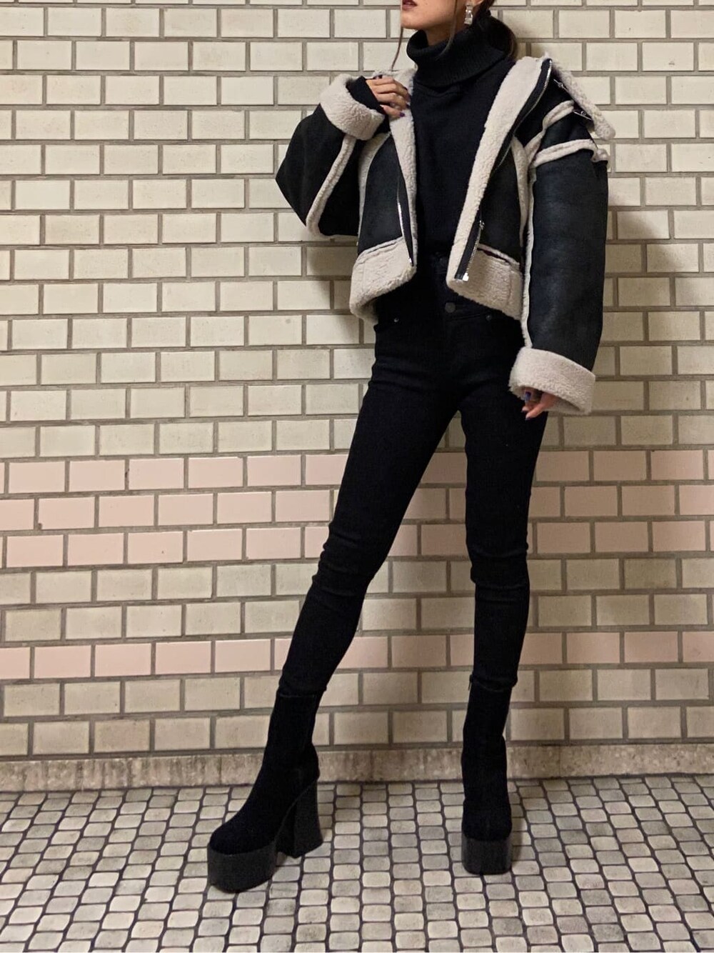 その他のムートンコート、ブラック系のブーツ、ブラック系のニット/セーターを着用したレディースの秋コーディネートの6枚目の写真
