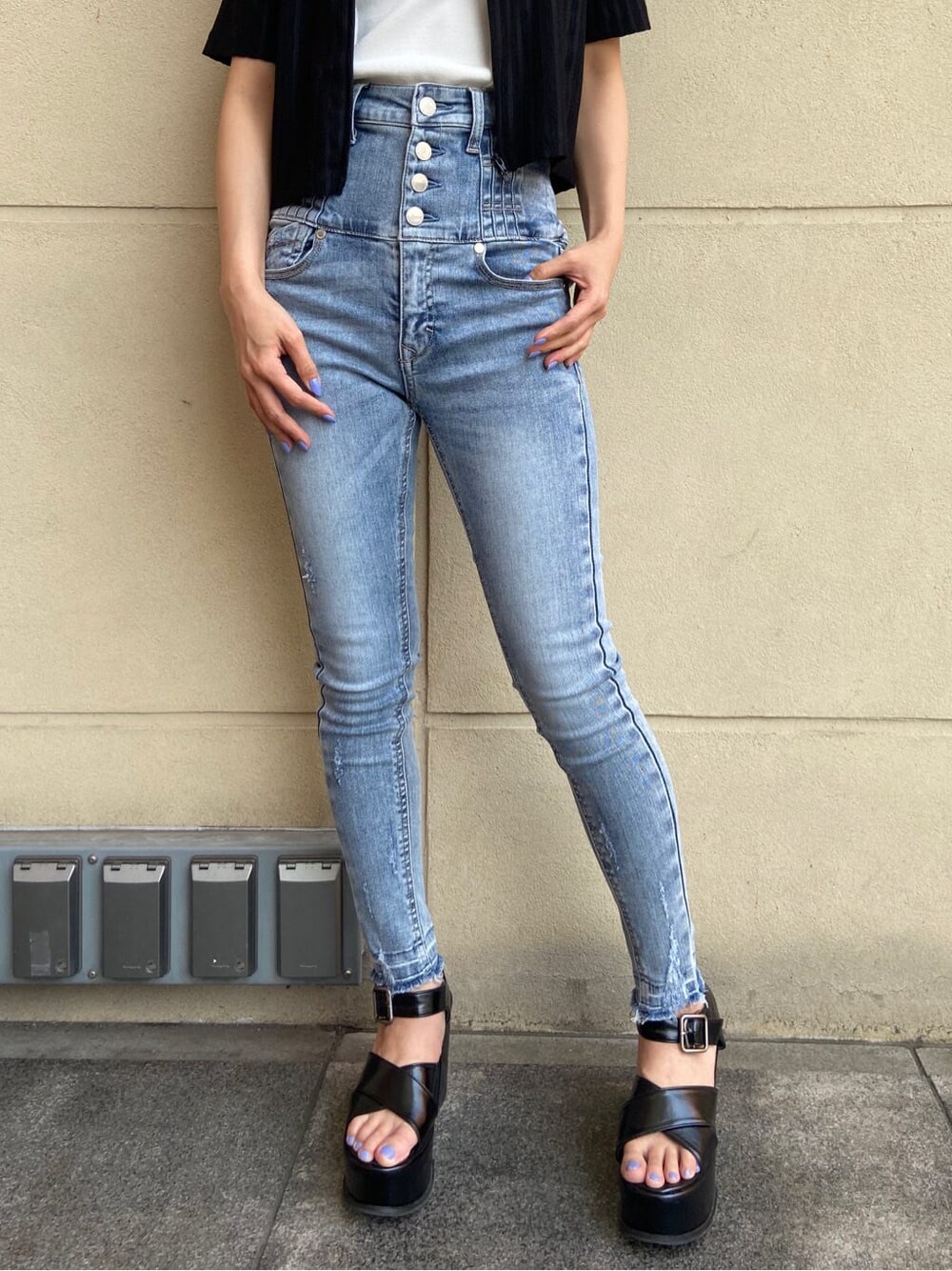 ブルー系のデニムパンツ、ホワイト系のタンクトップ、ブラック系のサンダルを着用したレディースの春コーディネートの7枚目の写真