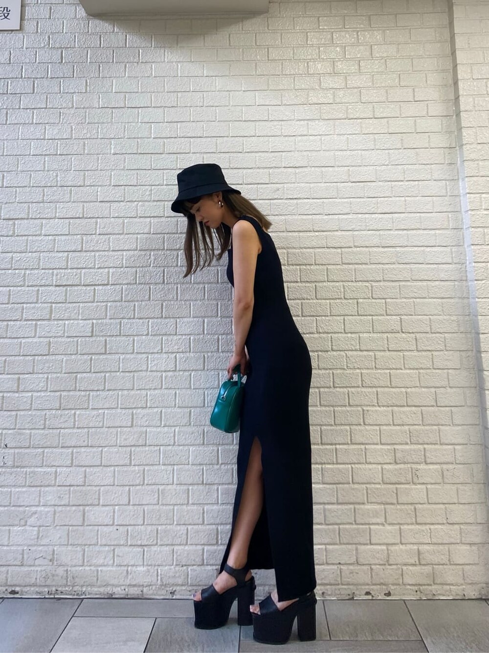 ブラック系のサンダル、ブルー系のショルダーバッグ、ブラック系のワンピースを着用したレディースの春コーディネートの3枚目の写真