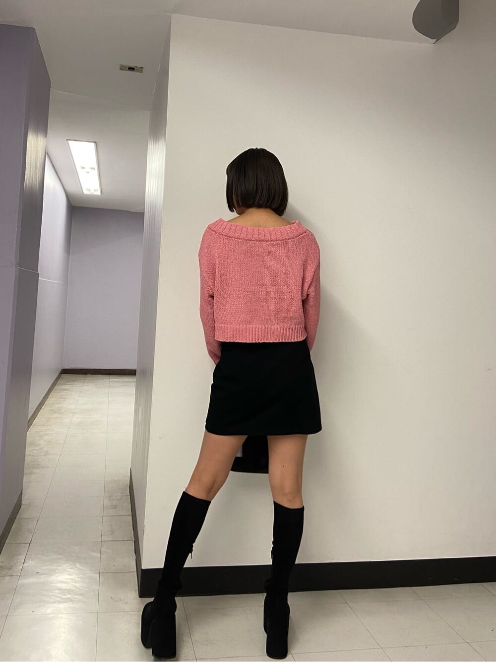 ブラック系のブーツ、ブラック系のスカート、ピンク系のニット/セーターを着用したレディースの秋コーディネートの2枚目の写真