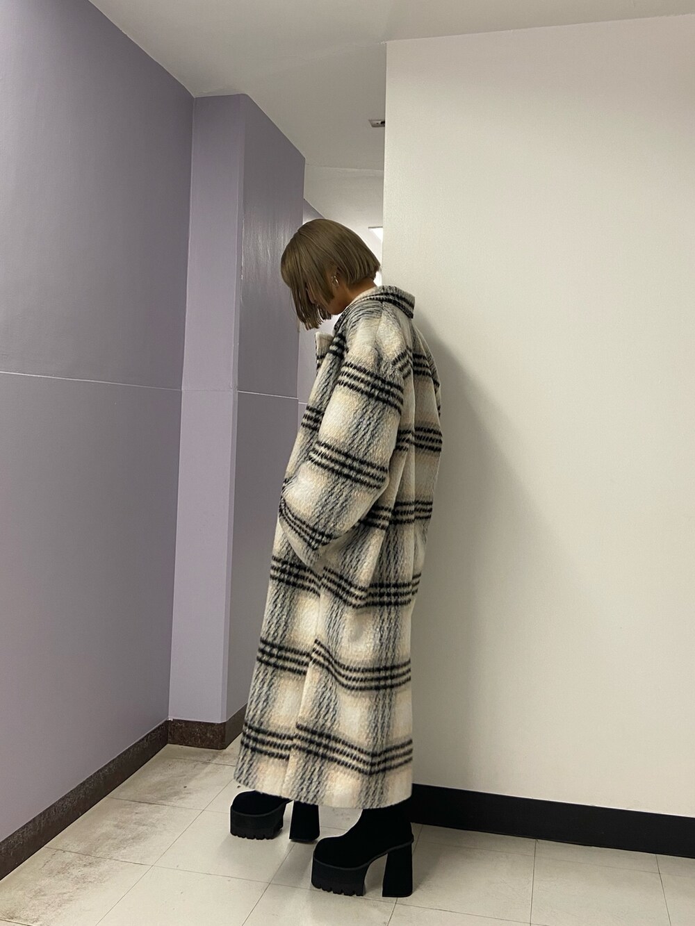 ブラック系のブーツ、ブラック系のスカート、その他のチェスターコートを着用したレディースの冬コーディネートの3枚目の写真