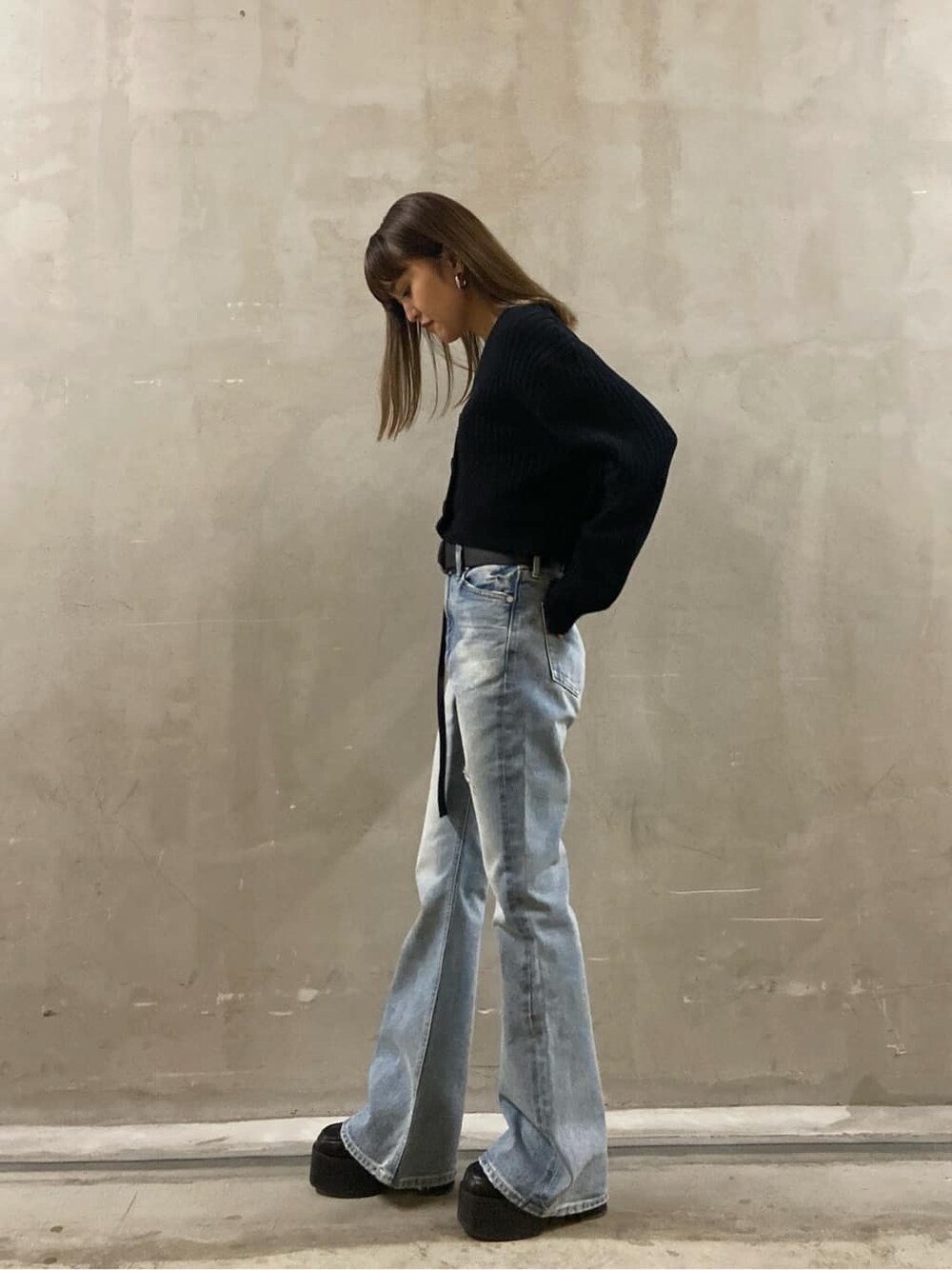 ブルー系のデニムパンツ、ブラック系のローファー、ブラック系のニット/セーターを着用したレディースの春コーディネートの2枚目の写真