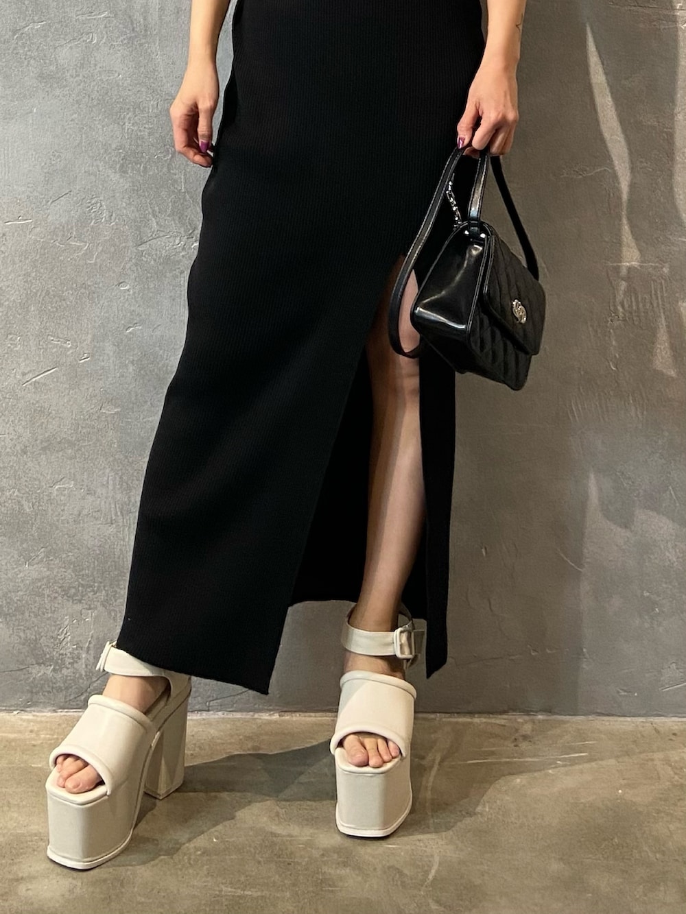 ブラック系のワンピース、ブラック系のショルダーバッグ、ホワイト系のサンダルを着用したレディースの春コーディネートの5枚目の写真