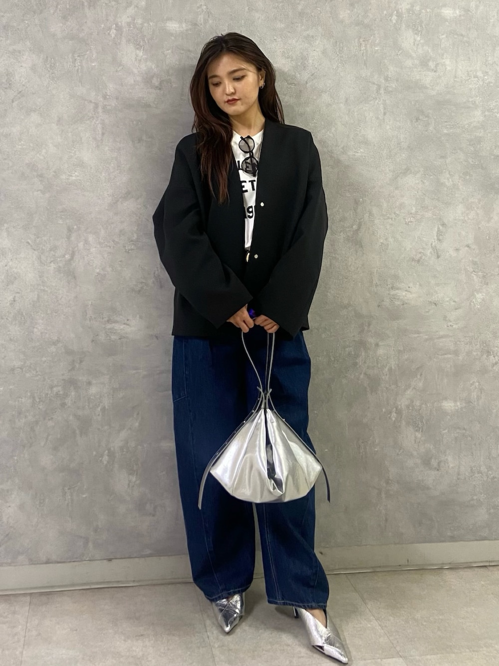 ブラック系のその他アウター、ホワイト系のTシャツ/カットソー、ブルー系のデニムパンツを着用したレディースの冬コーディネートの4枚目の写真