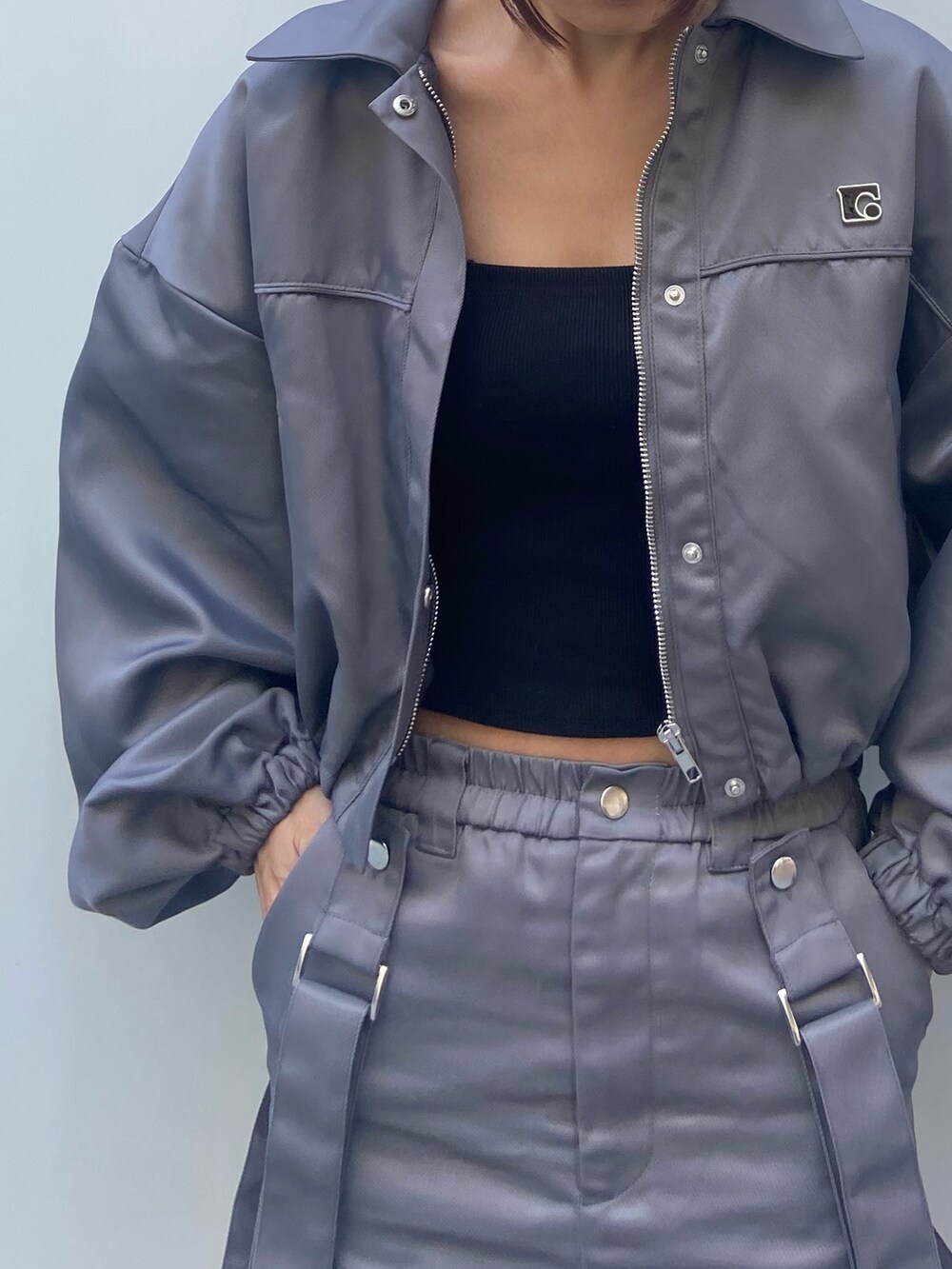 グレー系のブルゾン、ブラック系のキャミソール、グレー系のスカートを着用したレディースの冬コーディネートの4枚目の写真