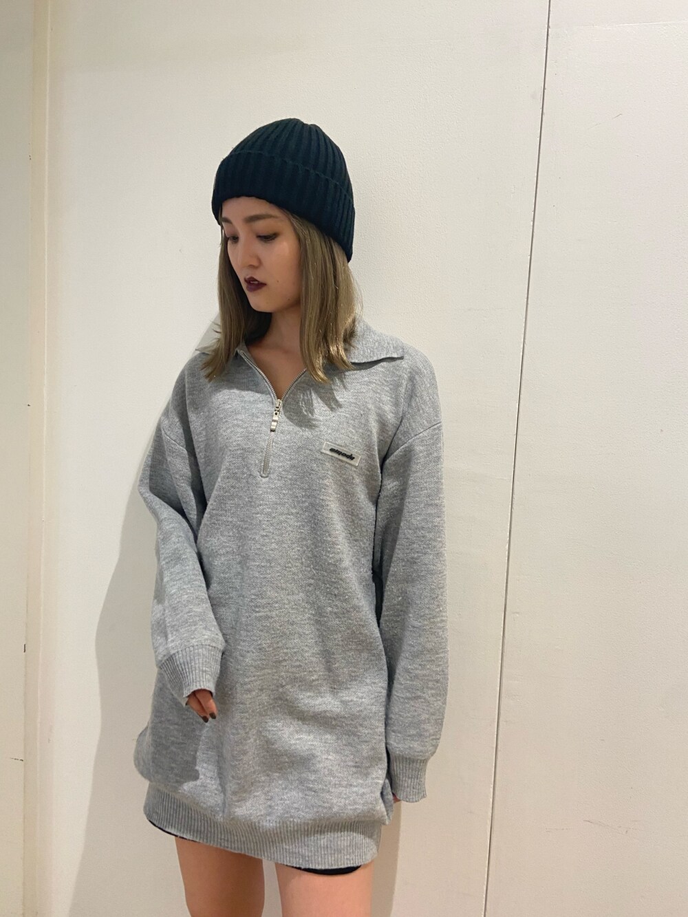 グレー系のワンピース、ブラック系のブーツ、ブラック系のニットキャップ/ビーニーを着用したレディースの秋コーディネートの5枚目の写真