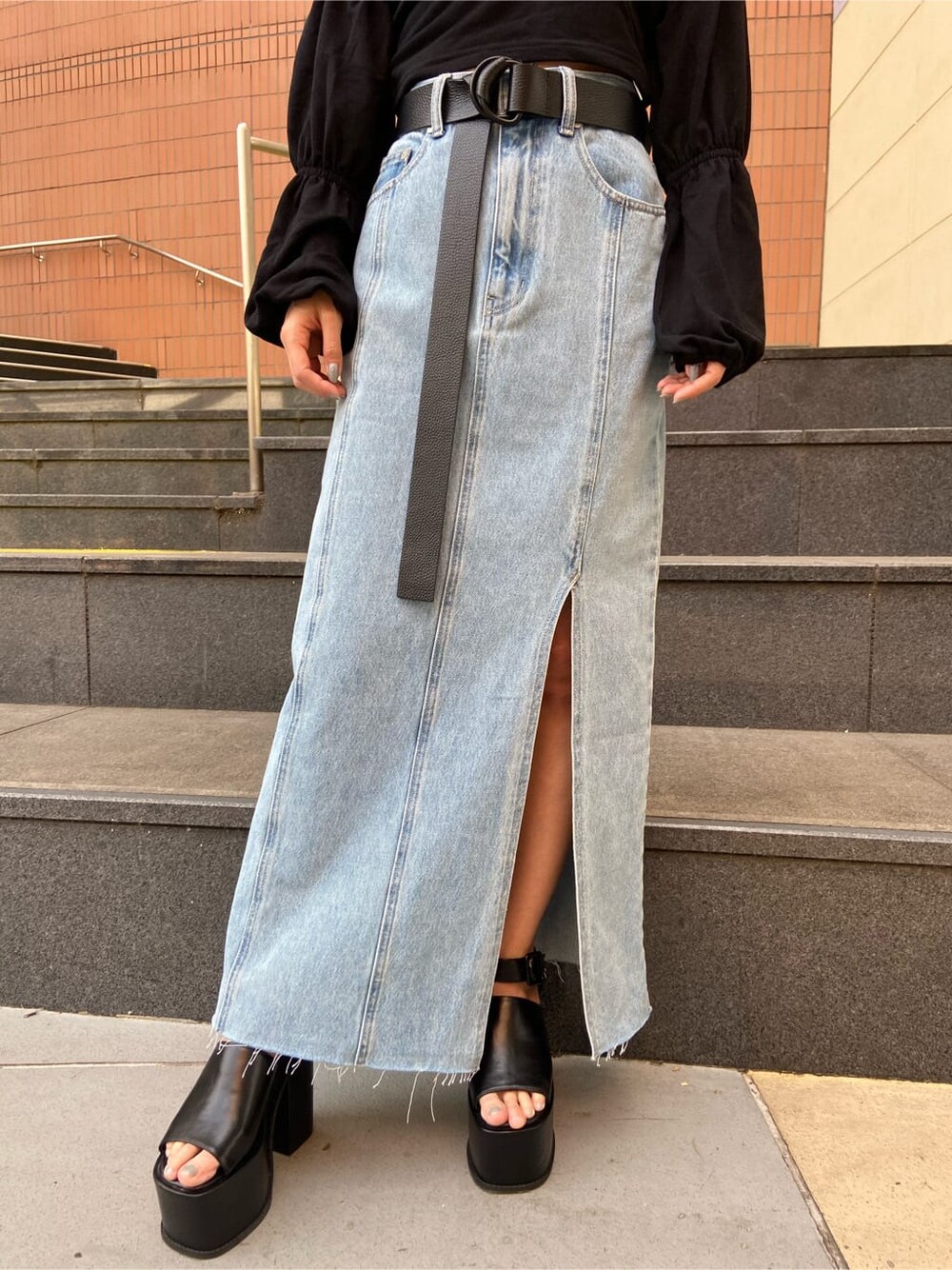 ブルー系のスカート、ブラック系のTシャツ/カットソー、ブラック系のサンダルを着用したレディースの春コーディネートの5枚目の写真