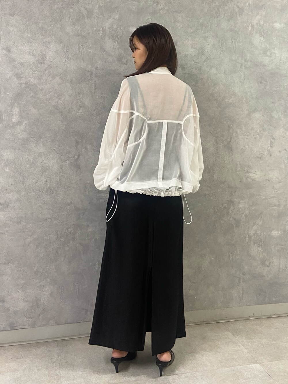 ホワイト系のブルゾン、ブラック系のタンクトップ、ブラック系のスカートを着用したレディースの春コーディネートの3枚目の写真