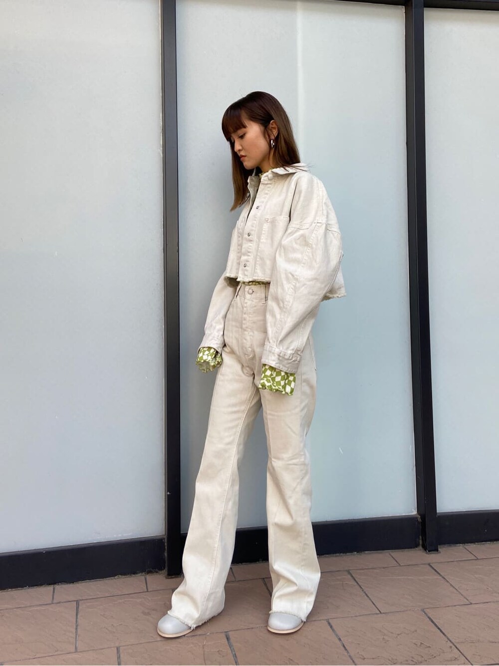 ホワイト系のデニムジャケット、グレー系のブーツ、その他のTシャツ/カットソーを着用したレディースの春コーディネートの3枚目の写真