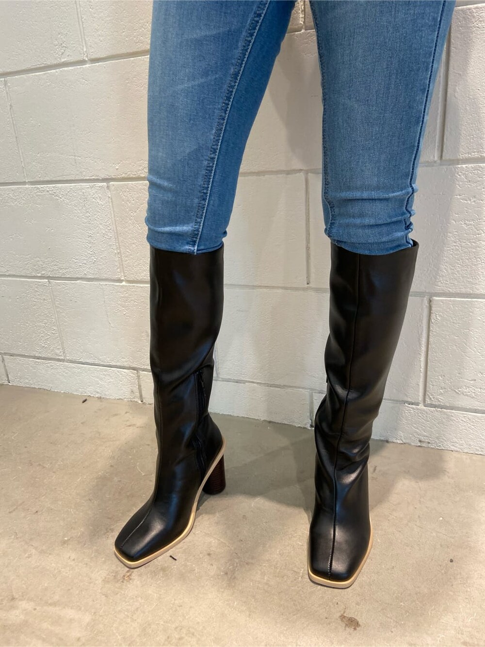 ブルー系のデニムパンツ、ブラック系のブーツ、ブラック系のニット/セーターを着用したレディースの冬コーディネートの5枚目の写真