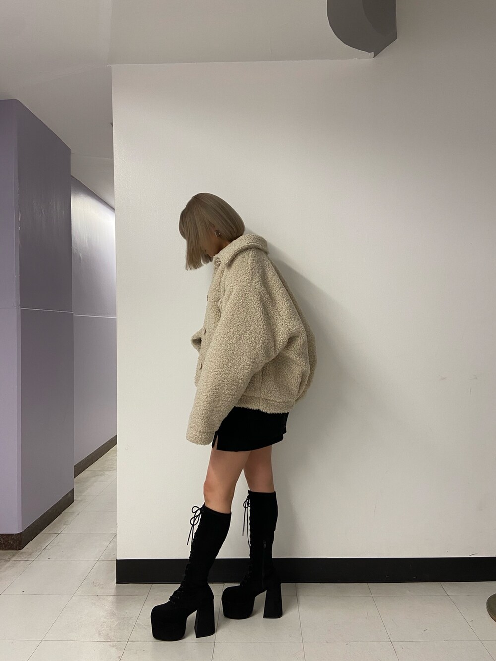 ブラック系のニット/セーター、ホワイト系のブルゾン、ブラック系のスカートを着用したレディースの冬コーディネートの3枚目の写真