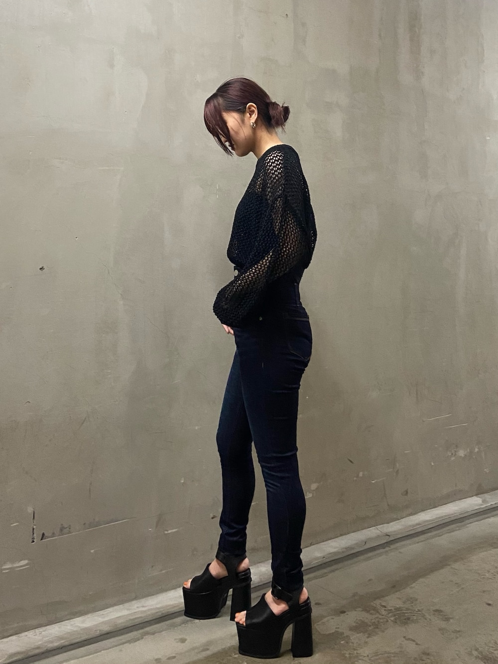 ブラック系のニット/セーター、ブルー系のデニムパンツ、ブラック系のサンダルを着用したレディースの春コーディネートの2枚目の写真