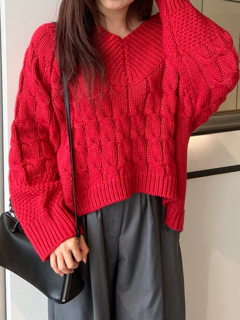 レッド系のニット/セーター、グレー系のその他パンツ、ホワイト系のパンプスを着用したレディースの冬コーディネートの4枚目の写真