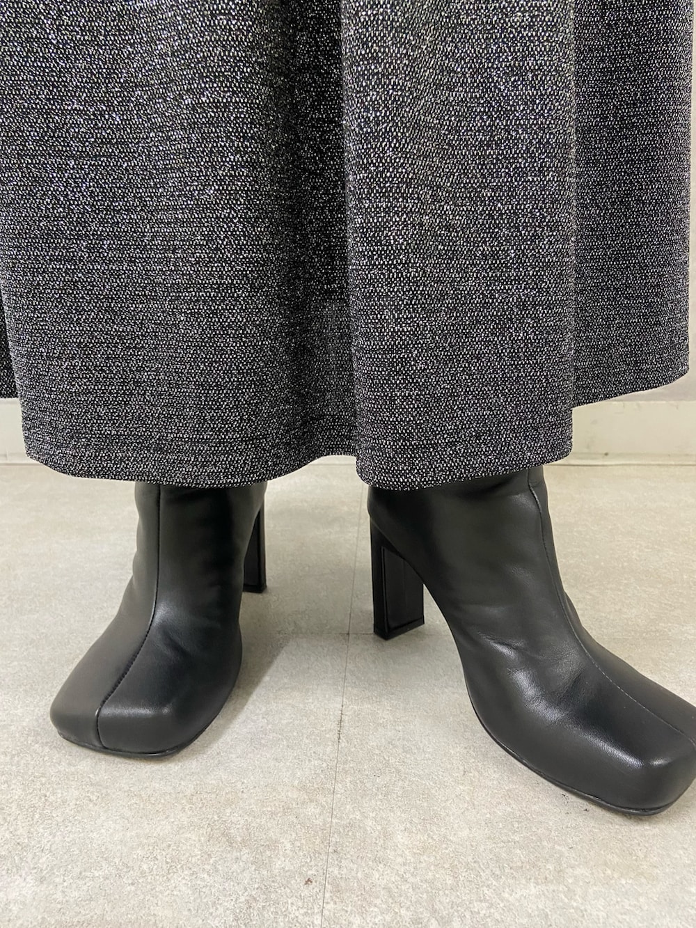 ブラック系のワンピース、ブラック系のブーツを着用したレディースの秋コーディネートの5枚目の写真