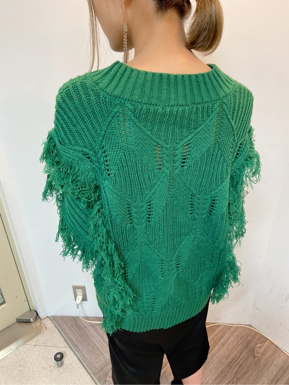 ブラック系のスカート、ブラック系のブーツ、グリーン系のニット/セーターを着用したレディースの秋コーディネートの3枚目の写真