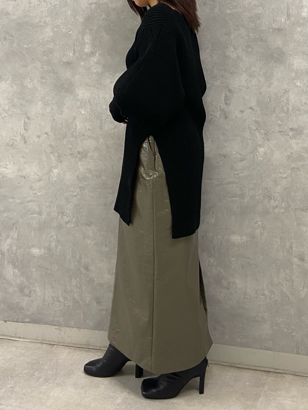 ブラック系のニット/セーター、グリーン系のスカート、ブラック系のブーツを着用したレディースの秋コーディネートの3枚目の写真