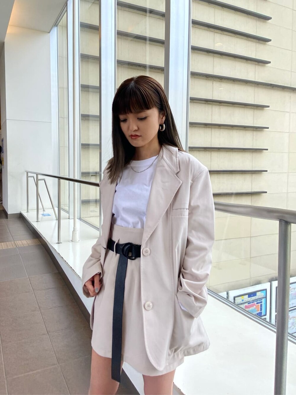 ホワイト系のテーラードジャケット、ブラック系のブーツ、ホワイト系のスカートを着用したレディースの春コーディネートの3枚目の写真